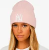 A woman wearing a pink New Era beanie with the NY Yankees logo. Náhľad obrázku produktu