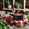 A pot of tomato soup with tomatoes and basil on a wooden table. Náhled obrázku produktu