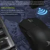A black gaming mouse is shown on a dark blue patterned mousepad, with a portion of a keyboard visible on the left. Text overlays describe features of the mouse. Podgląd zdjęcia produktu