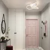 A modern hallway with a pink door, white cabinets, and a geometric ceiling light. Produktbild-Vorschau