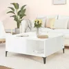 A white coffee table in a living room setting with a sofa and plant. Náhled obrázku produktu
