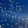A close-up shot of a string of LED lights coiled on a blue surface. Produktbild-Vorschau