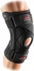 A person's knee wearing a black McDavid knee brace. Podgląd zdjęcia produktu