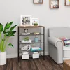 A storage shelf with items placed on it, next to a sofa and a plant. Produktbild-Vorschau