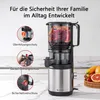 A slow juicer is shown with callouts highlighting its safety features, set against a kitchen counter with fruit in the background. Produktbild-Vorschau