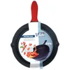 A black cast iron frying pan with a red silicone handle grip is displayed against a white background. The pan has a label attached to it. Anteprima dell’immagine prodotto