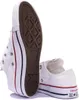 A close-up shot of two white Converse All Star low-top sneakers against a white background. One shoe is shown from the sole up, revealing the diamond pattern of the outsole and the red and blue stripes on the midsole. The other shoe is partially visible fr Voir les images du produit
