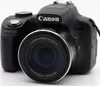 A black Canon PowerShot SX50 HS digital camera is shown against a white background. Produktbild-Vorschau