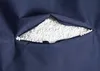 Close-up of a navy blue fabric with a zipper opening revealing white filling material. Produktbild-Vorschau