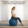 A pregnant woman is sitting on a blue exercise ball on a yoga mat in a room with natural light. Produktbild-Vorschau