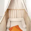 A baby crib with a bed snake and two pillows. Produktbild-Vorschau