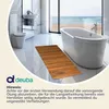 A bathroom with a bathtub, toilet, sink, and a wooden bath mat, with a view of the ocean through a large window. Produktbild-Vorschau