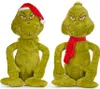 Two plush toys of the character The Grinch are shown against a white background. One is wearing a Santa hat, and the other is wearing a red scarf. Produktbild-Vorschau