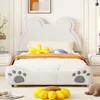 A child's bed with a bear-ear shaped headboard and paw print details on the footboard, decorated with stuffed animals and a blanket. Produktbild-Vorschau