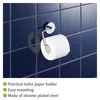 A toilet paper holder with a roll of toilet paper mounted on a dark blue tiled wall. Produktbild-Vorschau
