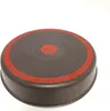 The bottom of a brown baking pan with a red circular design and red markings around the edge. Voir les images du produit