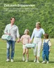 A family walking in a grassy field with picnic blankets. Produktbild-Vorschau