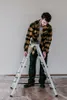 A man is adjusting a ladder indoors. Anteprima dell’immagine prodotto