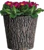 A potted plant with pink flowers and green leaves in a brown planter with a wood-like texture. Produktbild-Vorschau