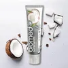 A tube of BIOMED SUPERWHITE toothpaste is shown with pieces of coconut and coconut halves scattered around it on a white background. Anteprima dell’immagine prodotto