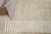A close-up view of a textured rug with geometric patterns in beige and cream tones. Anteprima dell’immagine prodotto