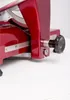 A close-up view of a red meat slicer. Náhled obrázku produktu
