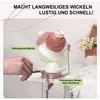 A hand is using a yarn winder to wind pink yarn. The background includes a shelf with flowers and more yarn. Produktbild-Vorschau