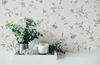 A tray with a plant, a candle, and a decorative bunny figurine sits on a white surface against a floral wallpaper background. Produktbild-Vorschau