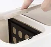 A finger is shown pressing down on the lid of a white and beige dual compartment trash can. Náhľad obrázku produktu