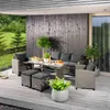 A polyrattan lounge set is arranged on a wooden deck, with a garden and a building in the background. Náhled obrázku produktu