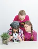 Three children are gathered around a microscope on a table, looking at a plant sample. Anteprima dell’immagine prodotto