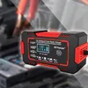 A car battery charger is shown in a studio setting with a blurred background of car parts. Podgląd zdjęcia produktu