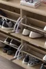 A close-up view of a wooden shoe cabinet with multiple shelves and shoes on display. Produktbild-Vorschau