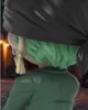 A close-up view of the back of a stylized figurine, showing its green hair, black headscarf, and green jacket. Anteprima dell’immagine prodotto