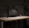 A desk setup with a monitor, keyboard, lamp, and coffee cup. Náhled obrázku produktu