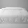 A white duvet cover with a subtle striped pattern is shown laid out on a bed against a plain gray background. Produktbild-Vorschau