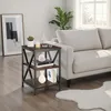 A side table with decorative items next to a sofa in a living room. Produktbild-Vorschau