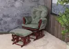 A green upholstered rocking chair and ottoman set with a wooden frame, placed on a white rug in front of a stone wall and a wooden paneled wall. Voir les images du produit