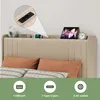 A bed with a headboard featuring integrated charging ports and a shelf displaying electronic devices. Produktbild-Vorschau