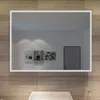 A bathroom mirror with LED lighting mounted above a sink, reflecting a room with artwork on the wall and a door. Náhled obrázku produktu