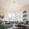 A modern living room with a sectional sofa, large windows, and plants. Produktbild-Vorschau
