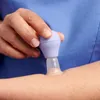 A close-up shot of a person's arm with a medical device being applied. Náhled obrázku produktu