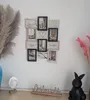 A collage of framed photos and decorative items displayed on a wall above a shelf. Produktbild-Vorschau