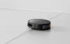A black robot vacuum cleaner is shown on a light gray floor with a white border along the wall. Produktbild-Vorschau