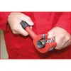 A person's hands are using a red pipe cutter to cut a metal pipe. Anteprima dell’immagine prodotto