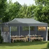 A pop-up party tent set up in a garden with picnic tables and benches inside. Anteprima dell’immagine prodotto