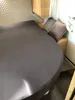 A bed with a fitted sheet in a room, possibly a campervan or caravan. Produktbild-Vorschau