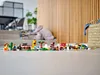 A collection of small LEGO builds, including animals and vehicles, arranged on a floor in a home setting. Produktbild-Vorschau