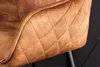 A close-up view of a brown upholstered chair with diamond stitching. Produktbild-Vorschau