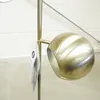 Close-up of a brass lamp head with a tag attached to the stand. Produktbild-Vorschau